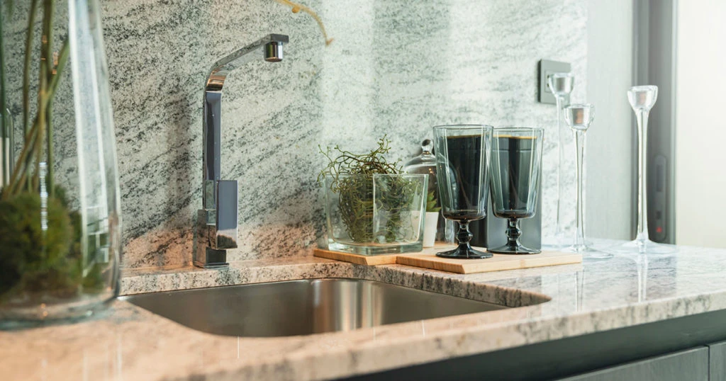 kitchen sink with marble slab backsplash